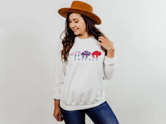 Buffalo Bills Josh Allen football sweatshirt in white paired with medium wash jeans and a tan brimmed hat.